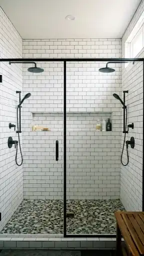 Spacious walk-in shower with two shower heads and black frame glass.