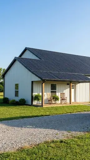Exterior view of a small white farmhouse style barndominium with a black porch.